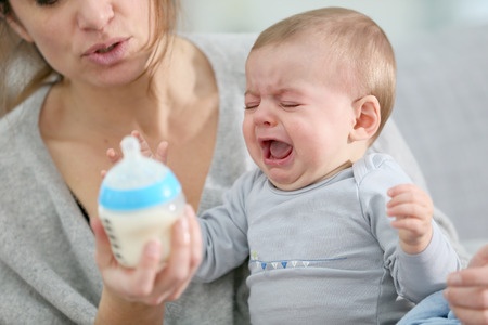 baby crying with bottle